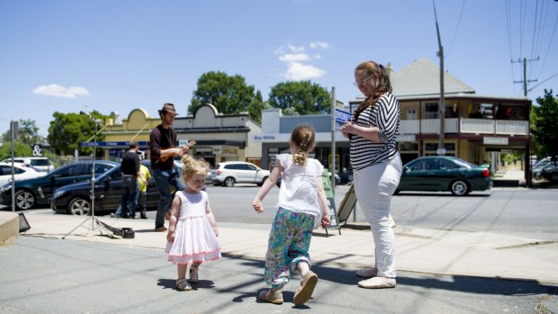 Rebecca Carpenter and her daughters Eliza, 4, and Victoria, 2, dance  in the streets of Braidwood to burn off some energy on the trip to the coast.
