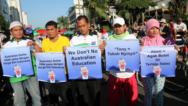 Indonesians hold posters aimed at Tony Abbott during protests in Jakarta.