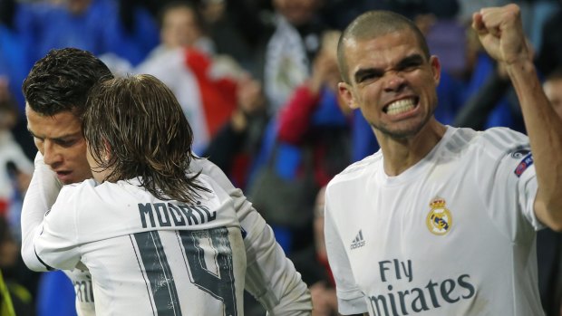 Happy days: Luka Modric hugs Ronaldo, left, as Real Madrid's Pepe clenches his fist.
