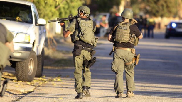 Police at the scene of a shootout about a mile from the site in San Bernardino where gunmen left at least 14 dead.