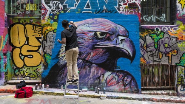 Street artist creating graffiti at Hosier Lane in Melbourne.