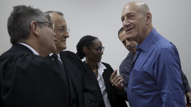 Ehud Olmert with his lawyers on Monday.
