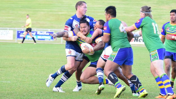 Canberra big man Ben Sione is wrapped up by the Newcastle defence.