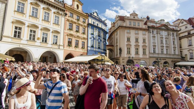 Thousands of tourists visit Prague's old town during peak season.