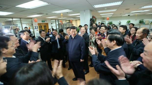Workers applaud as Chinese President Xi Jinping, centre, talks with editors in the general newsroom of the People's Daily in Beijing on Friday.