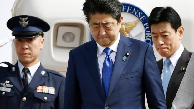 Japanese Prime Minister Shinzo Abe, centre, arrives back from India, in Tokyo on Friday as news broke of the North Korean missile launch.