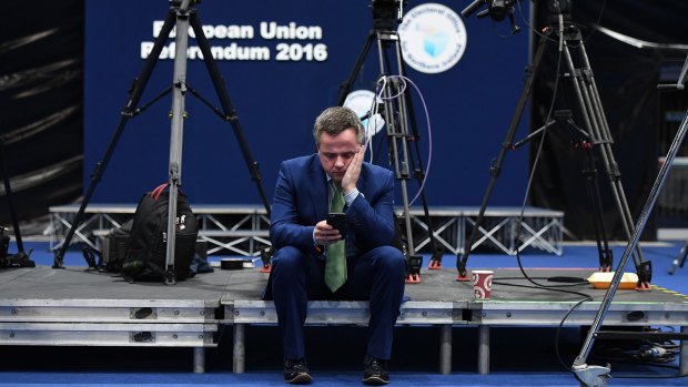 A Remain campaigner checks his  phone for updates at the EU referendum count in Belfast, Northern Ireland.  