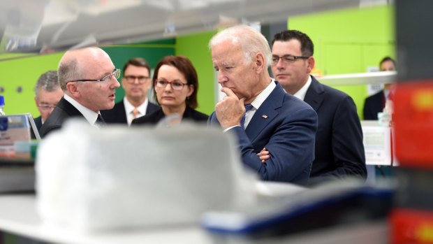 Professor Sean Grimmond, who investigates ovarian and pnacreatic cancer genomes, shows Health Minister Susan Ley, US Vice President Joe Biden and  Victorian Premier Daniel Andrews around a research labs at the Victorian Comprehensive Cancer Centre.