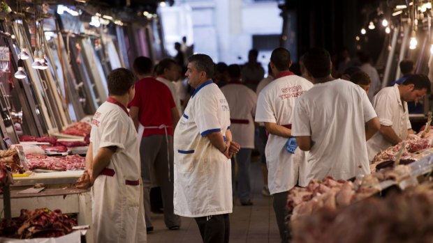 Butchers wait for clients in a meat market in central Athens on Tuesday. 