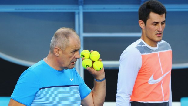 Bernard Tomic listens to his father and coach John Tomic during a practice session before the Australian Open 