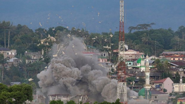 Debris fly as Philippine Air Force fighter jets bomb suspected locations of Muslim militants in Marawi on Friday.