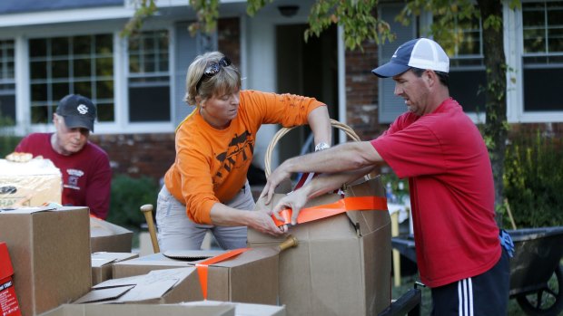 Lucy Mahan and Curtis Player work to secure a friend's belongings on Tuesday after their home was flooded in South Carolina.