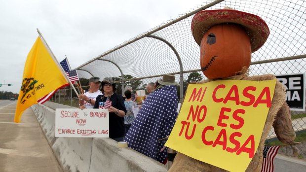 Protesters line an overpass in Texas during a protest last year against people who immigrate illegally.