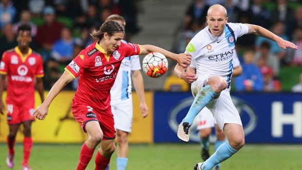 Aaron Mooy of Melbourne City (right) and Michael Marrone of Adelaide United fight for possession.