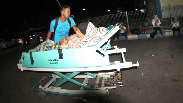 A man pushes a relative on a hospital bed in Padang as they evacuate following the earthquake.
