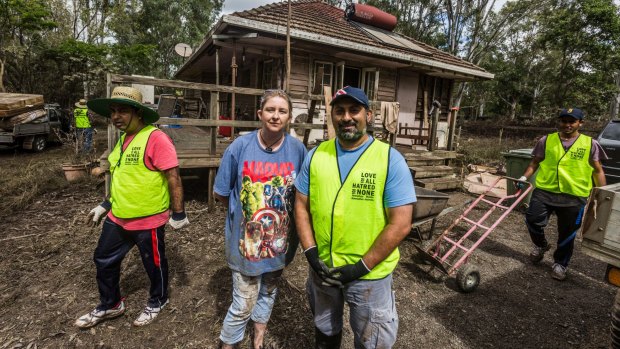 Jacinta Huch with Haroon Chowdhary, a volunteer from the Ahmdiyya Muslim Association of Queensland, cleaning up at Bayes Road, Logan Reserve after the recent flooding.
