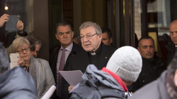 Cardinal George Pell reads a statement to reporters as he leaves the Quirinale hotel after meeting with survivors of sex abuse.