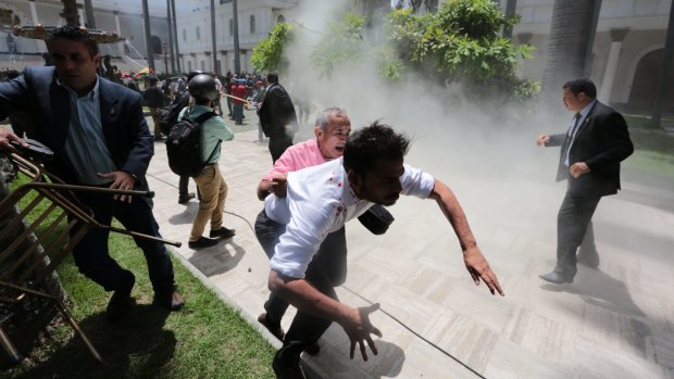 National Assembly workers run from an attack by pro-government militia members. 