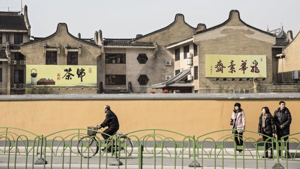 Riding a bicycle past a row of traditional style Chinese buildings near Longhua Temple in Shanghai earlier this month. 