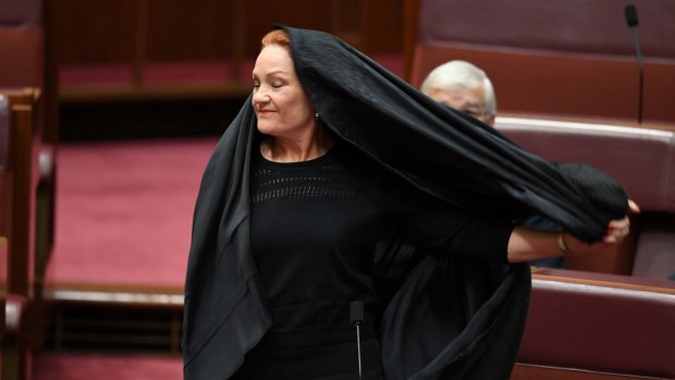 One Nation Senator Pauline Hanson takes off a burqa during Senate Question Time at Parliament House in Canberra in August.