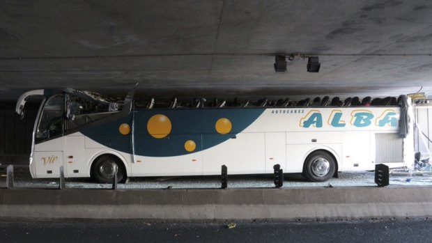 A Spanish tour bus with its roof sheared off under a bridge in La Madeleine, France, near Lille, on Sunday.