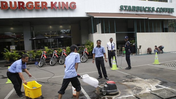 Workers clean up the spot where the militants involved in Thursday's attack were killed in Jakarta, Indonesia.
