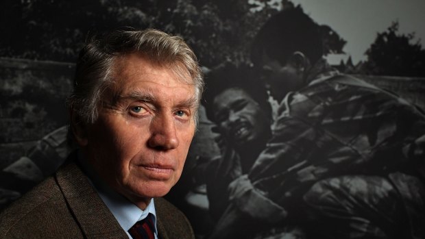 British photojournalist Don McCullin poses next to one of his images of war from an exhibition at the Imperial War Museum.