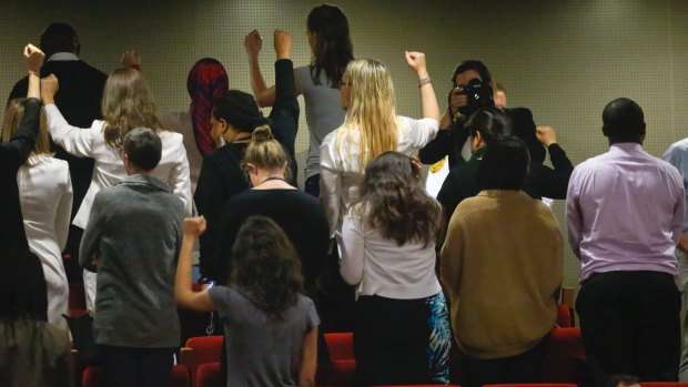 UN staff  turn their backs, top, in a silent protest against the appointment of Wonder Woman as ambassador for women and girls.