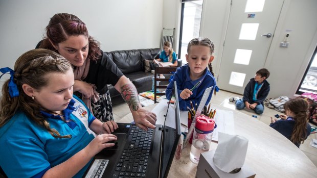 School's in: National School For Travelling Show Children employee Katherine Blanchard, centre, teaches Chivani and Mekia McDonald and three other show worker children in a Braybrook caravan park flat.