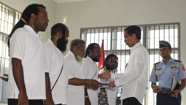 Indonesia's President Joko Widodo (right) hands over official pardons to five Papuan political prisoners belonging to the Free Papua Movement at a jail in Jayapura in May 2015.