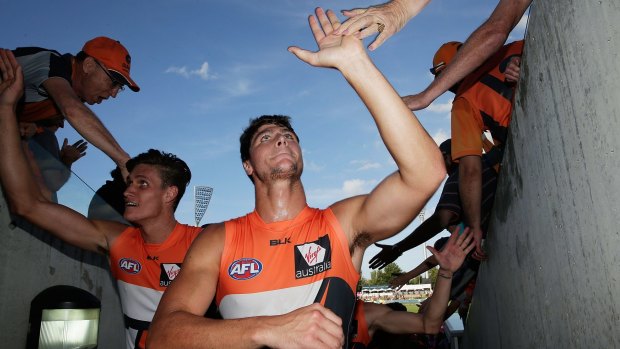 GWS Giants forwards Jonathon Patton and Rory Lobb celebrate with fans after victory against Geelong at Manuka Oval this year.