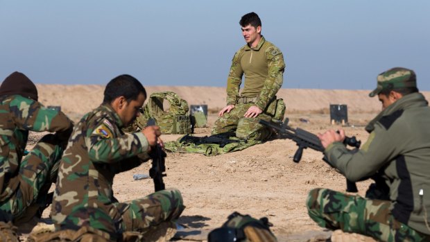 Australian Army soldier Corporal Emmette Taylor, from Task Group Taji 4, teaches Iraqi Security Forces personnel how to strip a K-2 assault rifle in Iraq.