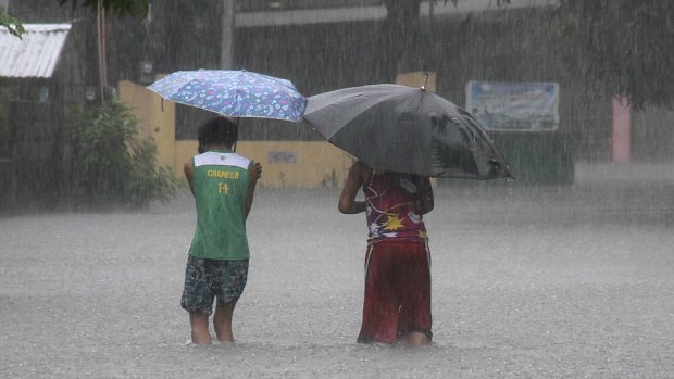 Residents wade across floodwaters caused by Typhoon Goni in Bacnotan, northern Philippines on Sunday.