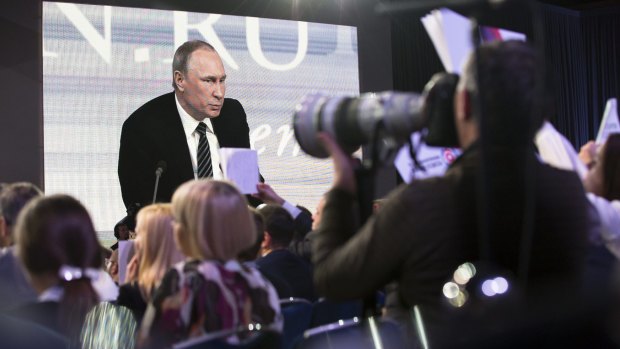 Russian President Vladimir Putin speaking at his annual end of year news conference is projected on a screen, in Moscow on Thursday. 