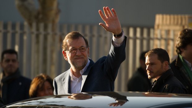 Spanish Prime Minister Mariano Rajoy waves after casting his vote at a polling station in Madrid on Sunday. 