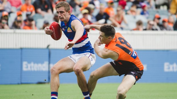 Western Bulldogs' Fletcher Roberts tries to avoid Giant Jeremy Cameron. 