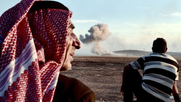People watch strikes on Kobane from Mursitpinar on the Turkish side of the Turkey-Syria border.