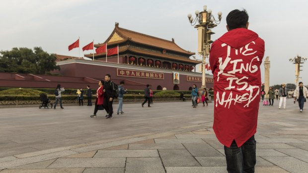 Tourists and pedestrians walk past a portrait of former Chinese leader Mao Zedong at Tiananmen Square in Beijing.