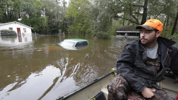Hunter Baker surveys flood damage to his neighbourhood near the flooded Black Creek following heavy rains in Florence, South Carolina on Monday.