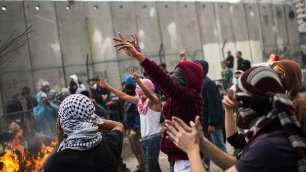 Palestinian youths clash with Israeli police in the Shuafat refugee camp, after a resident of the camp was named as the driver of the vehicle in Wednesday's Jerusalem attack.