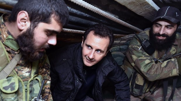 Syrian President Bashar al-Assad, centre, speaks with Syrian troops during a visit to the front line in eastern Damascus  last year.