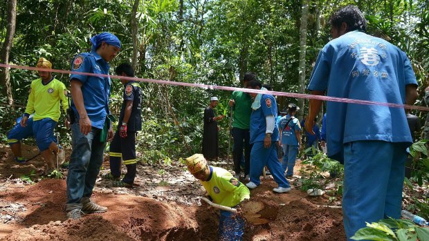 Rescue workers find a grave containing human remains near hillside site where shallow graves containing 26 bodies were found earlier this month.