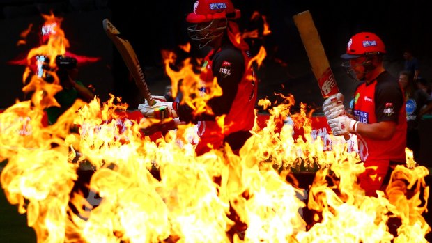 Chris Gayle and Aaron Finch of the Renegades walk through flames to open the batting on Wednesday night.