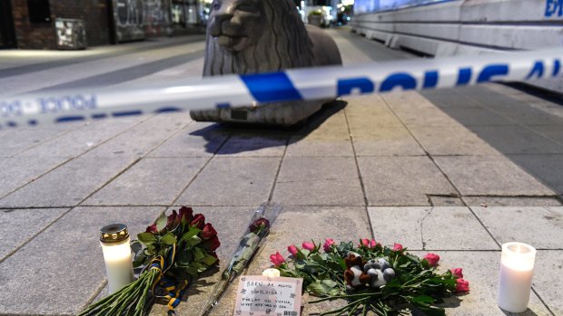 Candles and flowers are placed near the site where a beer truck crashed into a department store in central Stockholm on Friday.