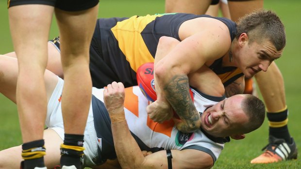 In close: Tom Scully is tackled by Dustin Martin during the tight encounter.
