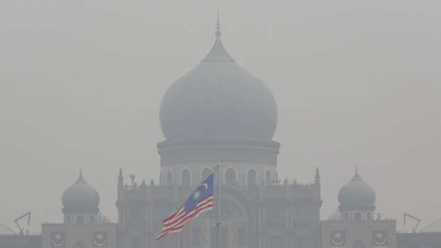 A Malaysian flag flutters in front of the prime minister's office shrouded in haze in Putrajaya, Malaysia, at the weekend.