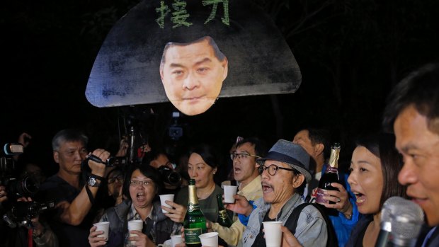 Pro-democracy protesters display a picture of Hong Kong chief Leung Chun-ying outside the Hong Kong Government House, as they celebrate on Saturday.