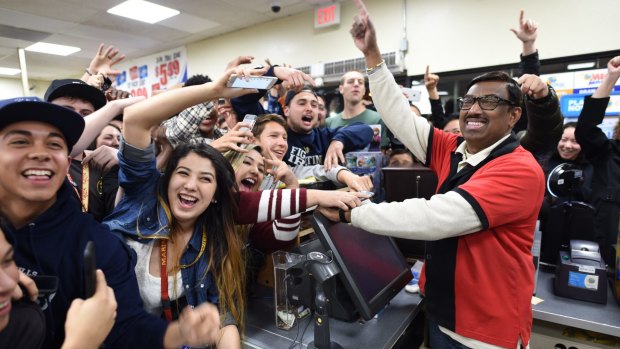 Customers celebrate with M Faroqui after the record Powerball draw.