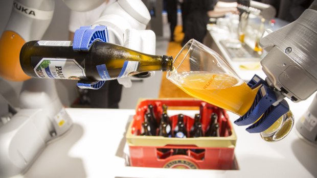 An industrial robotic arm pours a glass of beer at the Automatica trade fair in Munich on Tuesday.
