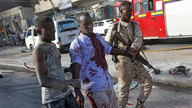 A Somali soldier helps a civilian wounded in the blast.